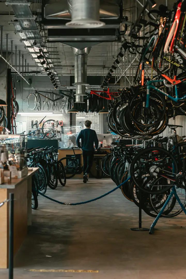Mecánico de bicicletas ajustando una rueda en el taller